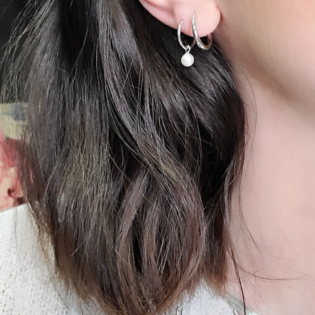 Woman wearing pearl huggies