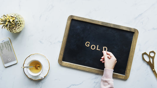 Woman Spelling out Gold with Golden Letters on Coffee Break