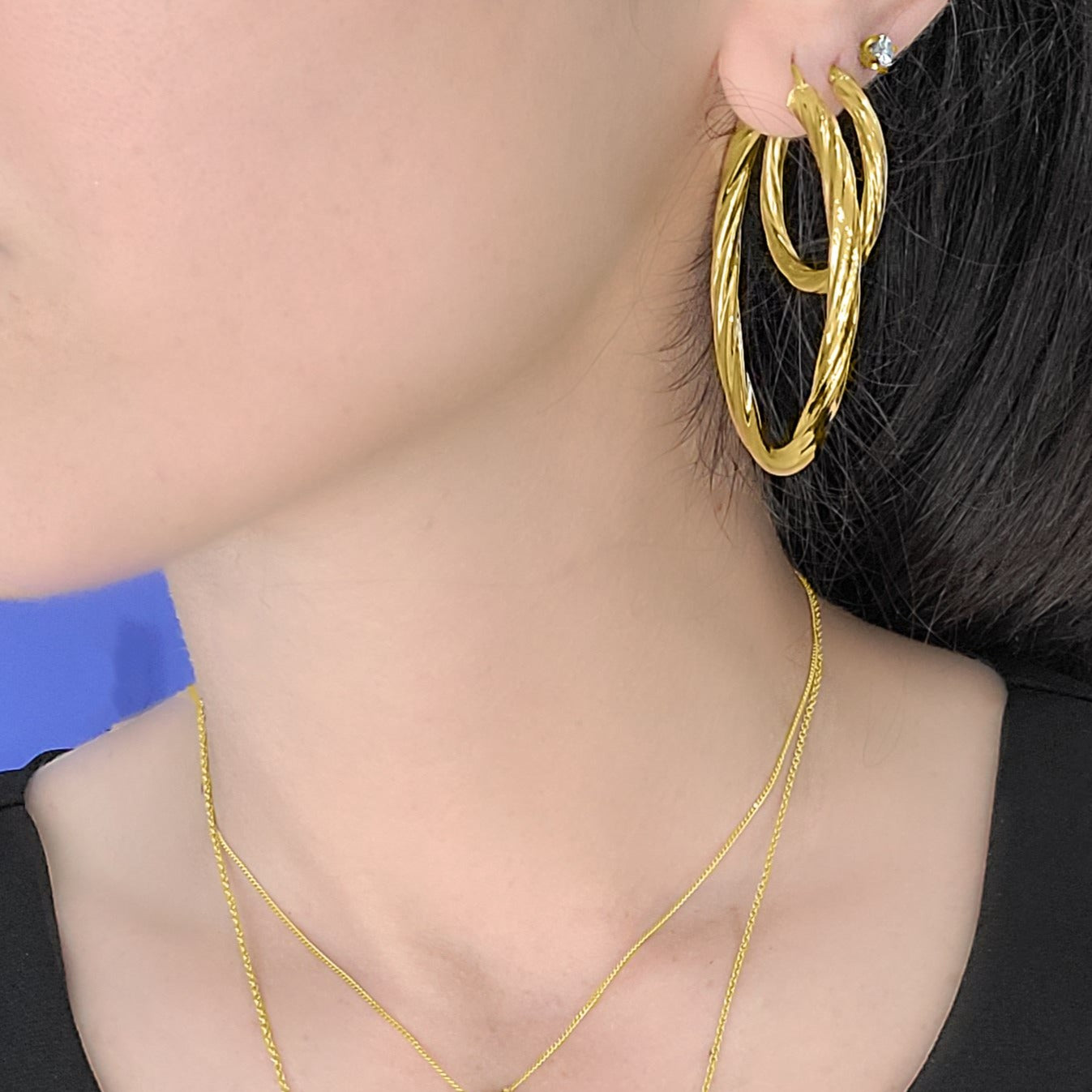 woman wearing extra-large textured gold hoops