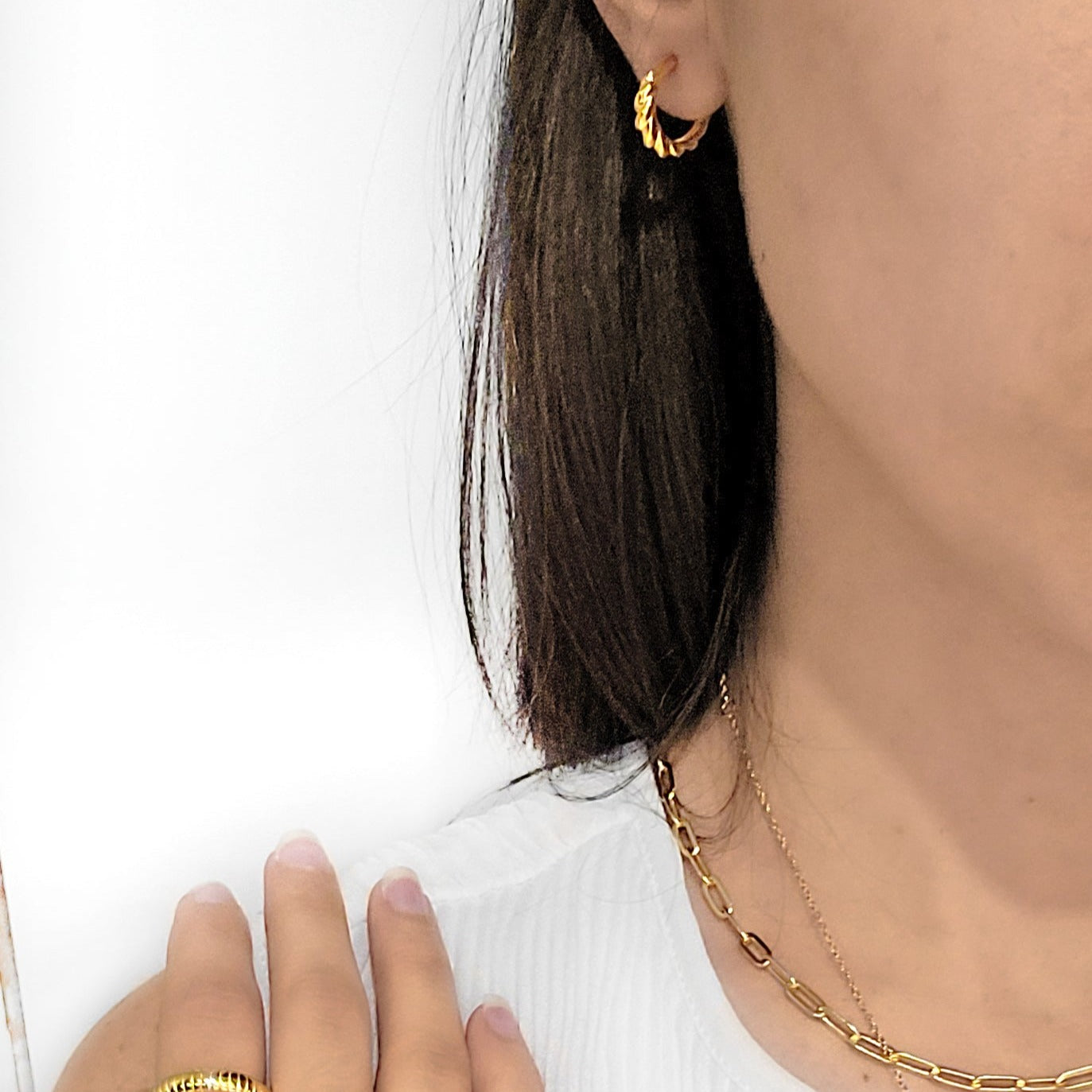 woman wearing gold cornetto earrings