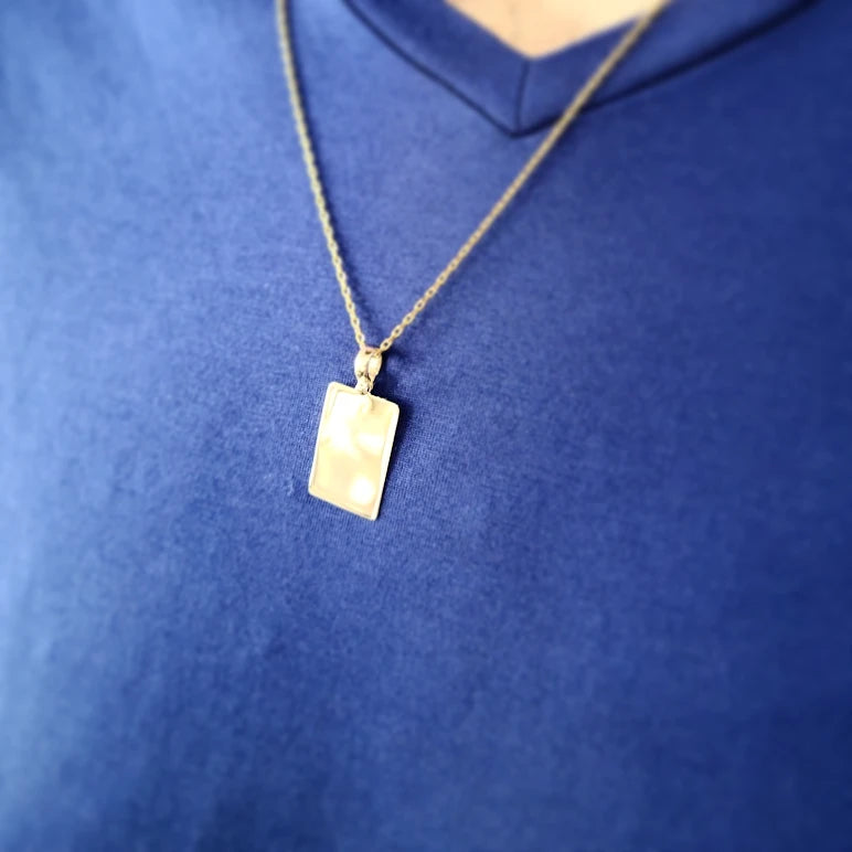 Man wearing solid gold tag pendant