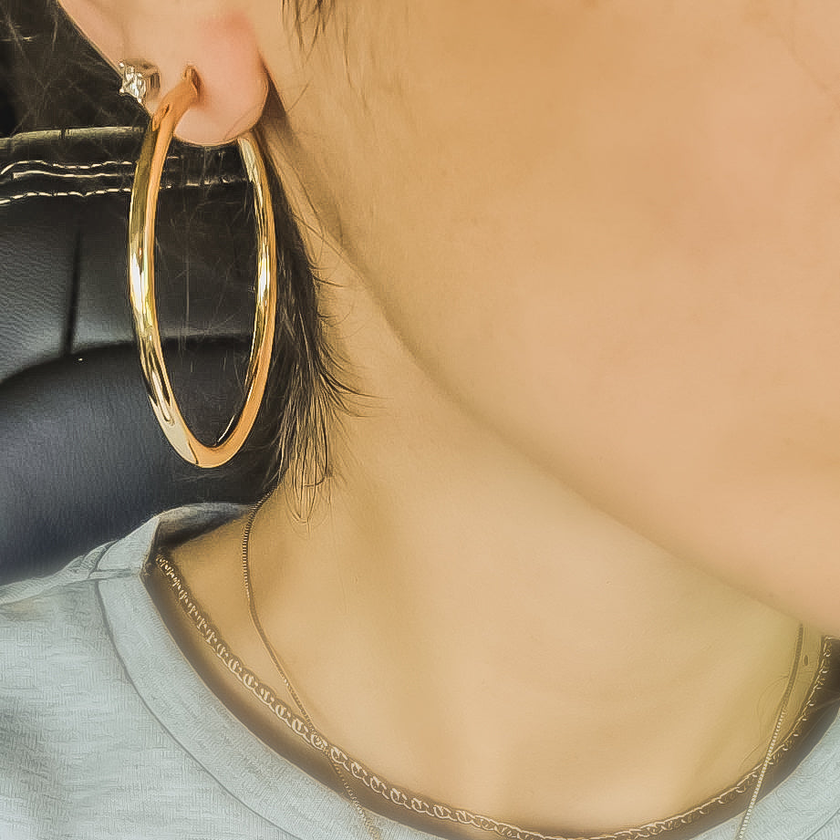 10KT Yellow Gold Extra Large Hoop Earrings worn by a Woman