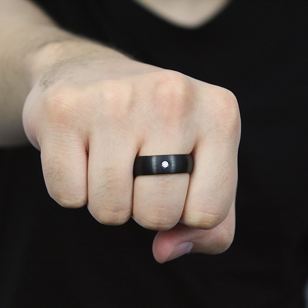 Black Tungsten Carbide Ring with a Brushed Finish and a Yellow-Gold Plated Inlay and one set Cubic Zirconia worn by a man 2